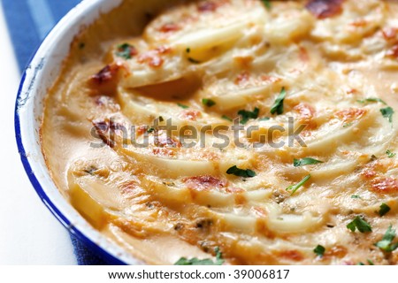 Scalloped potatoes in an old blue enamel bowl.  Shallow depth of field.