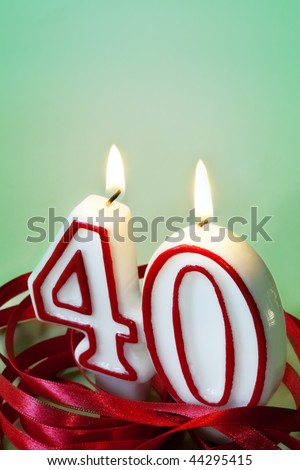 Number 40 candles, surrounded by red ribbon.  40th birthday or anniversary.