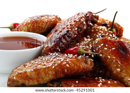 Chili chicken wings with a dipping sauce.  Topped with sesame seeds.  Delicious sticky eating!