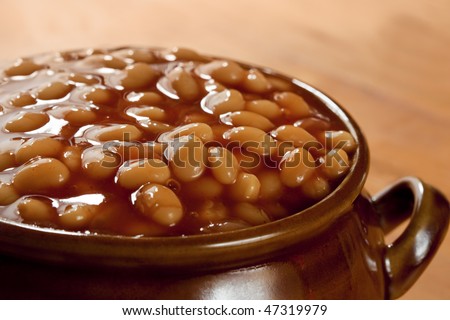 Baked beans in tomato sauce, in a brown pot.