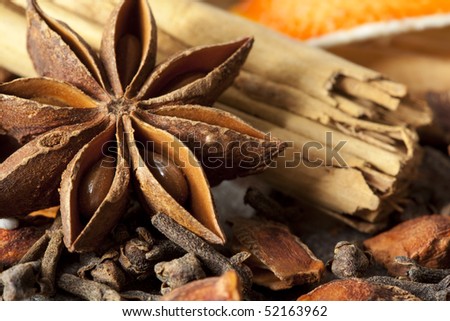 Mulling spices, including star anise, cinnamon sticks, cloves, and dried orange.
