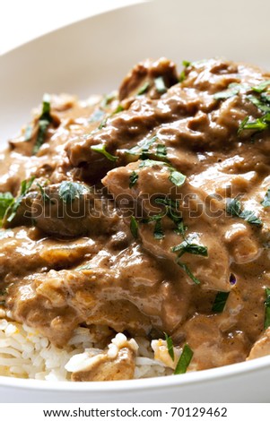 stock photo : Beef stroganoff over white rice, garnished with parsley.