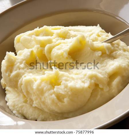 Mashed potato with spoon, in serving bowl.