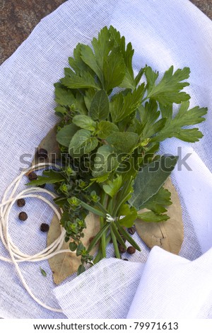 Bouquet garni of fresh herbs and peppercorns, on muslin ready for tying.
