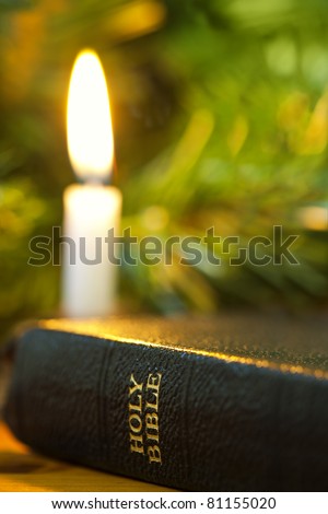Old Bible with Christmas candle.  Focus on words \