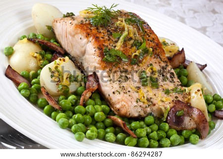 Grilled Atlantic salmon with baby peas, crispy bacon, chat potatoes, and a herb vinaigrette.