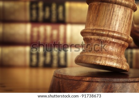 Gavel, with defocussed law books behind.