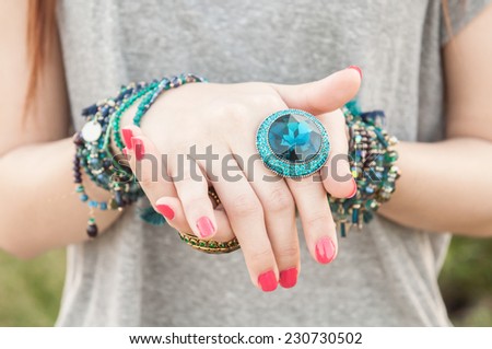 portrait of beautiful young brunette woman posing in rings and multiple bracelets