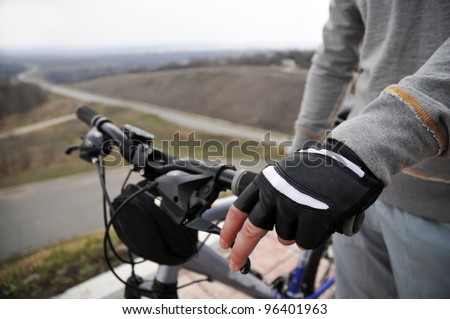 Hand of man is holding the brake lever on a bike. Hands on a bike handlebar