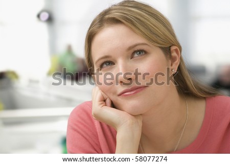 A Young Woman Has Her Hand On Her Chin As She Thinks. She Is Looking 