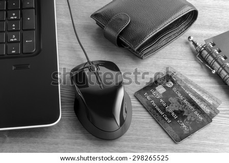 Electronic payments from desktop. Black and white composition on the subject of using modern means of payment for online shopping. Photo and graphic compositing.