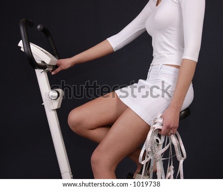 Nice young women body on body-bike with long measuring tape in hand
