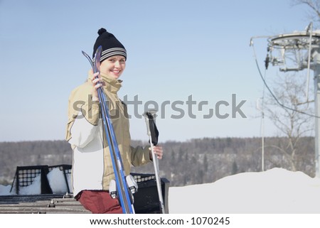 Girl with ski sitting on mountain retracking tractor chain