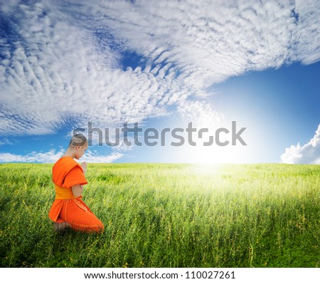 Monk pray in grass fields and blue sky