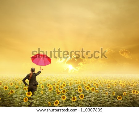Red umbrella Business woman standing in sunset over sunflowers field
