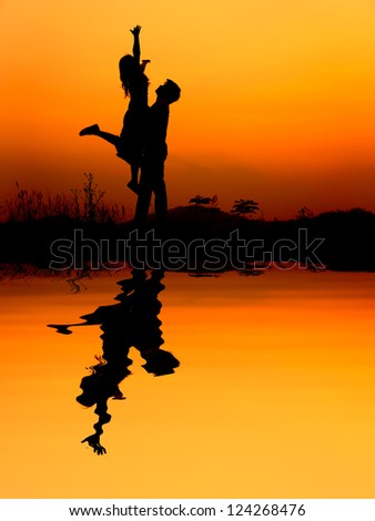 Reflection of Man and Woman love silhouette in sunset