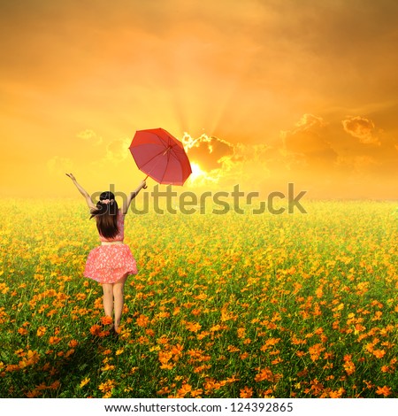 Happy woman holding red umbrella in cosmos flower field and blue sky