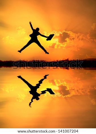 Reflect of Business woman jumping and sunset silhouette