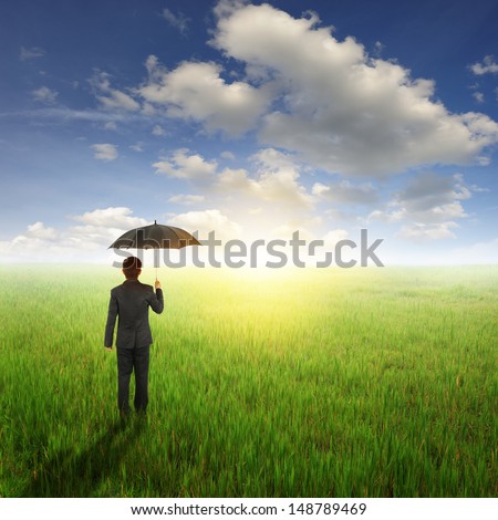 Umbrella man standing to sun sky in grassland with umbrella