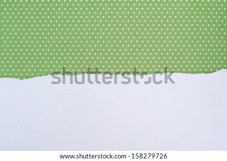 Ripped paper on green fabric