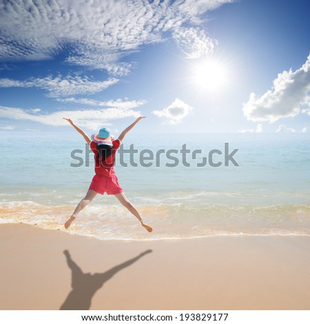 Happy Woman jumping on the beach and sun sky