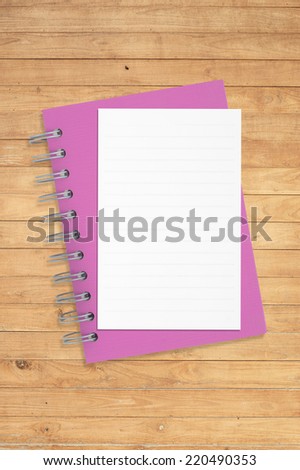Paper and  purple notebook  on wood table for background and text