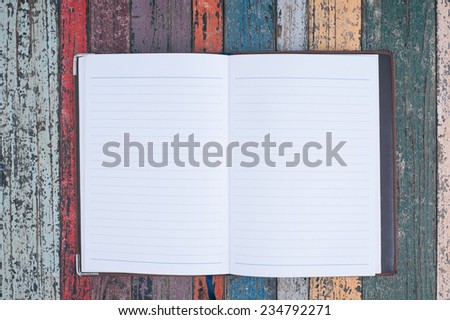 Open purple notebook  on vintage wood table for background and text
