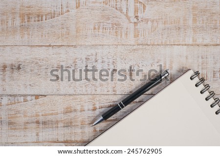 Notebook and pen on wood table for text and background