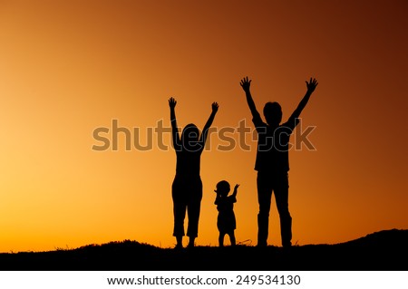 Happy family father mother and son playing outdoors at sunset silhouette