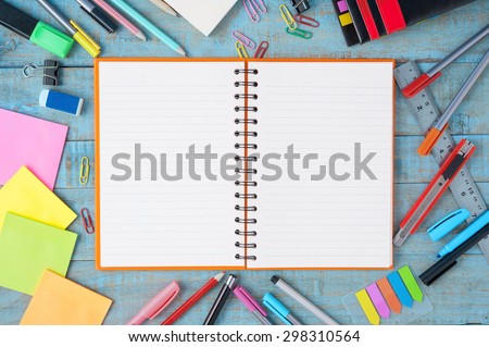 Notebook paper and school or office tools on blue vintage wood table for background