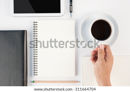 Man hand holding Cup of hot coffee tablet phone and notebook on  white background .copy space