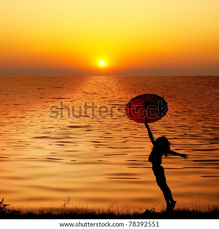 Umbrella woman jump and sunset silhouette in Lake