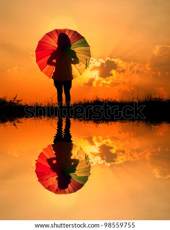 Umbrella woman and sunset silhouette,Water reflection
