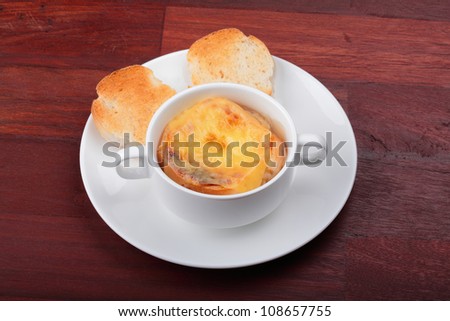 Onion soup and bread in breakfast set which on top of the table.