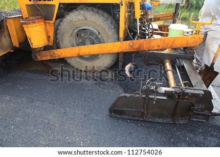 machine and worker at road construction