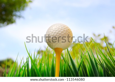 golf ball on yellow tee and blue sky background