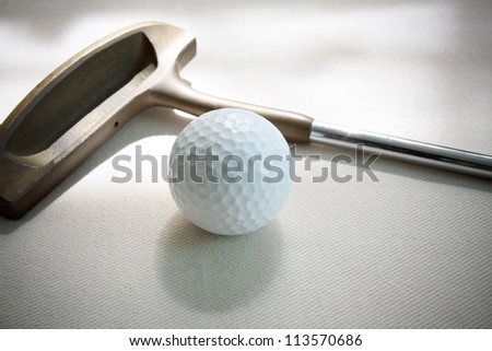 golf ball and putter lied on white floor