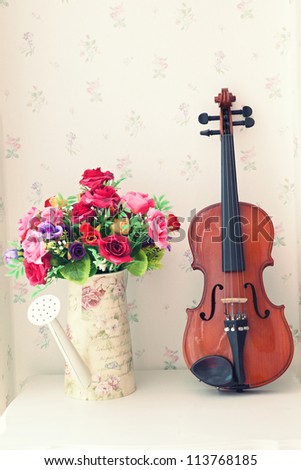 violin and bouquet flowers in jug home decorated