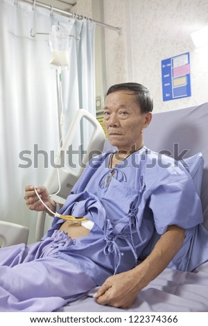 old man patient feeding liquid  food on hospital bed