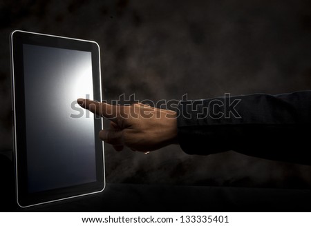 hand point to touching on tablet screen with dark background