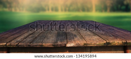 old wood table in field with green blur background use for outdoor background