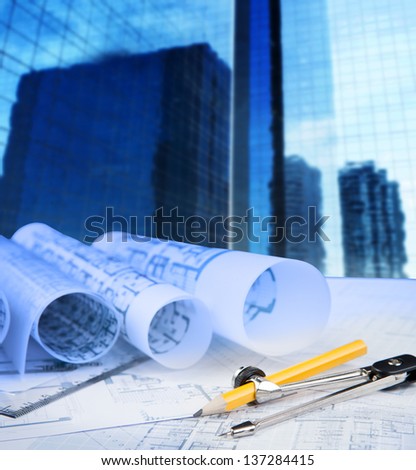 compass pencil blue print and office building in background use for construction theme