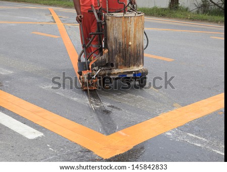 machine and worker at road construction use for road and traffic sign painting