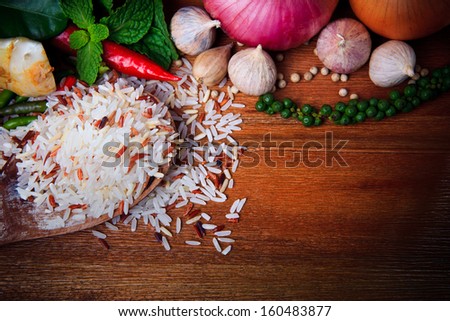 eastern food spice herb rice garlic chilly pepper mint leaves red onion green pepper on wood table background