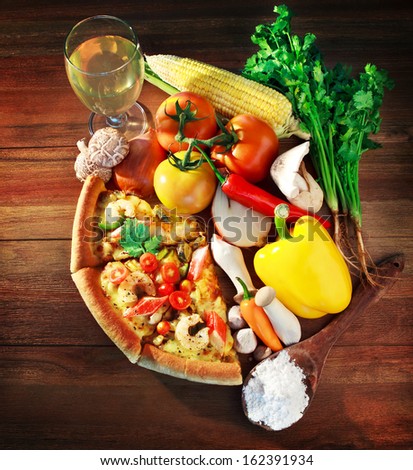 mixed contain and vegetable with  pieces of sea food pizza on wood table