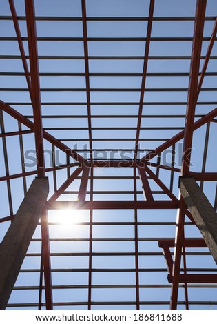 metal structure of house roof in home construction site and sun shining on blue sky use for construction business and construction industry