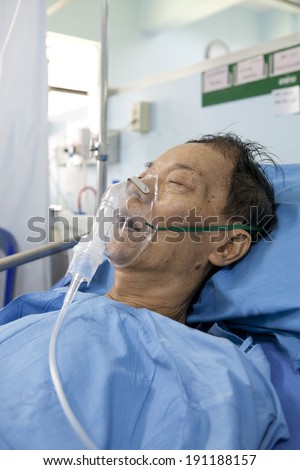 old man patient lying on icu hospital bed with oxygen mask