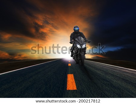 young man riding motorcycle on asphalt road against beautiful dusky sky use for land transport