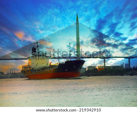 tanker ship in river against beautiful bridge with twilight sky of urban scene use for marine transport and freight industry business