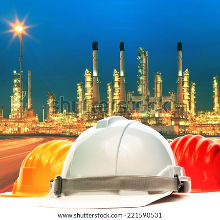 safety helmet against beautiful lighting of oil refinery plant in petrochemical industry estate use as industrial and safety topic background